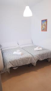 a bed with two towels sitting on top of it at Casa Lavanderas in Algodonales
