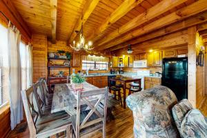 eine Küche mit einem Tisch und Stühlen in einer Hütte in der Unterkunft Fox Hollow in Little Cove