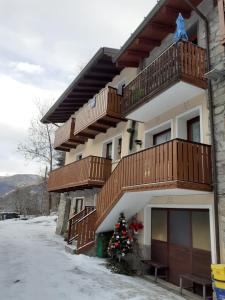 a building with a christmas tree in front of it at Soggiorno Vacanze Stella Alpina in Temù