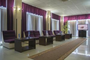 una sala de espera con sillas moradas y TV en Hotel Triumph en Brăila