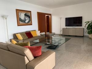 a living room with two couches and a television at Villa Dois Mares Puerto Calero in Puerto Calero