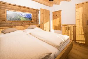 a bedroom with a white bed in a room with wooden walls at Erbhof Fritzing in Ebbs
