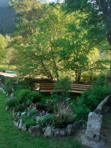 una panchina in un giardino con fiori e piante di Soggiorno Vacanze Stella Alpina a Temù