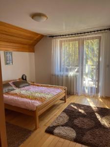 a bedroom with a bed and a large window at Villa Grand Jahorina in Jahorina