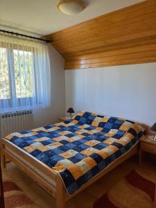 sypialnia z łóżkiem z kocem szachowym w obiekcie Villa Grand Jahorina w mieście Jahorina