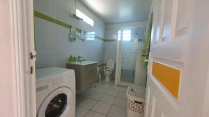 a white bathroom with a washing machine in it at Villa Campêche in Bouillante