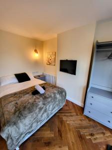 a bedroom with a bed and a flat screen tv at Unique and beautiful property in a quiet location. in Nottingham
