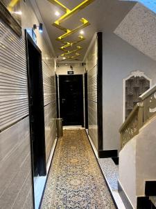 korytarzem z podłogą wyłożoną kafelkami w budynku w obiekcie Al Amir Palace Hotel w Sauhadżu