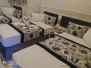 a room with three beds and two bedsitures at Al Amir Palace Hotel in Suwhaj