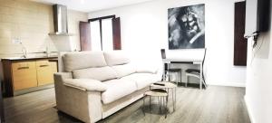 Una sala de estar con un sofá y una cocina. en ALMAALQUILER Clavería 11, en Almagro 21 fotos más