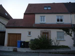 ein weißes Haus mit braunem Dach in der Unterkunft Maisonette-Wohnung in Nürnberg mit Kamin in Nürnberg
