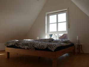 Bett in einem Zimmer mit Fenster in der Unterkunft Maisonette-Wohnung in Nürnberg mit Kamin in Nürnberg