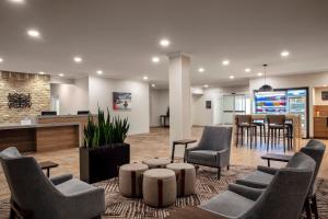 a lobby with chairs and a table and a bar at Candlewood Suites Mobile-Downtown, an IHG Hotel in Mobile
