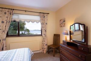 a bedroom with a mirror and a dresser and a window at Cottage 431 - Oughterard in Oughterard