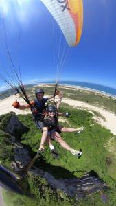 Dos personas están montando un paracaídas en la playa en Pousada Italianíssima en Arroio do Silva