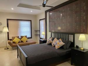 1 dormitorio con 1 cama grande y 1 sofá en Yasuragi Boutique Resort, en Shencottah