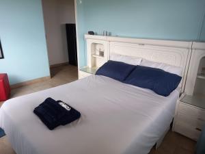 a white bed with a blue bag on top of it at Aqua on Newport street in Port Edward