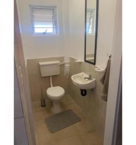 a small bathroom with a toilet and a sink at Aqua on Newport street in Port Edward