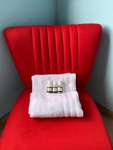a red chair with two white towels on it at Aqua on Newport street in Port Edward