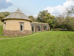 an old building in a field with a grass yard at The DugOut in Hereford