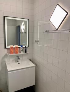 um banheiro branco com uma pia e um espelho em Appartement Ann em Blankenberge mais 13 fotografias