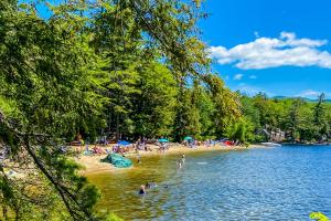 un grupo de personas en una playa en el agua en Victory Cottage at NH, en Moultonborough