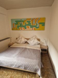 um quarto com uma cama e duas pinturas na parede em Ferienwohnung Wunderlich gelb em Münchberg