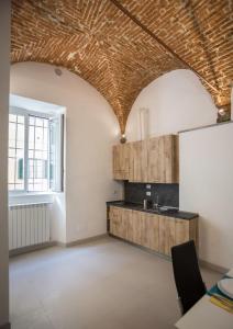 an empty room with a kitchen with a brick ceiling at Visit Florentia Apartment in Florence