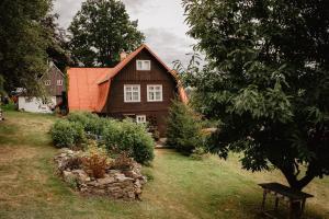 una casa de madera con techo naranja en un patio en Chata Rozárka, en Kořenov