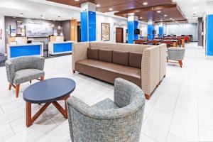 een lobby met een bank, stoelen en een tafel bij Holiday Inn Express & Suites - Stafford NW - Sugar Land, an IHG Hotel in Stafford