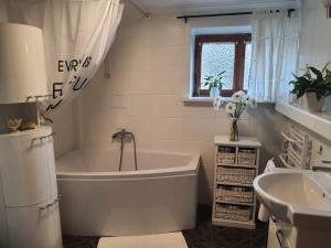 biała łazienka z wanną i umywalką w obiekcie Komfortowy apartament nad Zalewem Sulejowskim w Sulejowie