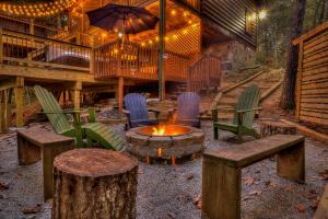 un patio con sillas y una hoguera en una cabaña en New! Treetop Cabin - Hot tub, Firepit & Fast WiFi, en Blue Ridge
