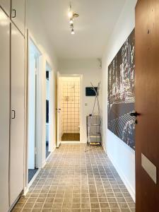 um corredor com piso em azulejo e uma pintura na parede em Randers residence Sankt Andreas - 2 room apartment em Randers