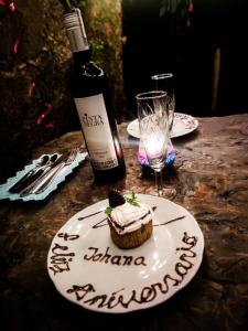 a bottle of wine and a plate with a cupcake on a table at Rincón Entre Piedras in Choachí