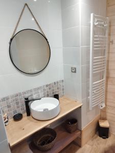 La salle de bains est pourvue d'un lavabo et d'un miroir. dans l'établissement Agréable maison au centre d'Arreau pour 8 pers, à Arreau