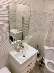 a bathroom with a sink and a toilet and a mirror at Sunny Home in Oral +8 photos