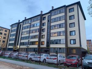 a large building with cars parked in front of it at Sunny Home in Oral