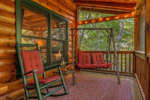 a porch of a cabin with two chairs and a swing at Golden Eagle GA Cabin - Hot Tub, Firepit & Fast WiFi in Blue Ridge