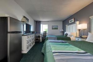 Habitación de hotel con 2 camas y escritorio en Buffalo Lodge, en Buffalo
