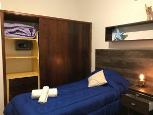 1 dormitorio con cama azul y cabecero de madera en Casa de Lola en Mar del Plata