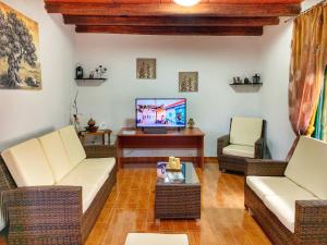 a living room with wicker chairs and a television at Evaggelias Home Gavalochori in Gavalochori