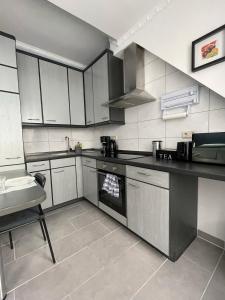 une cuisine avec des armoires blanches et un four à plaques de cuisson dans l'établissement Deluxe Apartment, à Wiesbaden