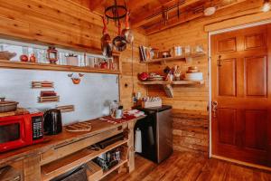eine Küche in einer Holzhütte mit einer roten Mikrowelle in der Unterkunft Treehouse-Eagles Perch over the water in Port Angeles