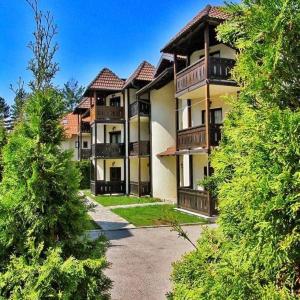 un gran edificio de apartamentos con balcones y árboles en Apartman Bella Zlatibor, en Zlatibor