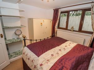 um quarto com uma cama num quarto com janelas em Tinkletod em Clevedon
