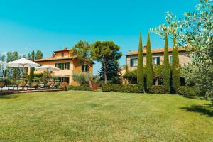 a house with a yard with chairs and trees at Agriturismo Il Borgo in Cortona