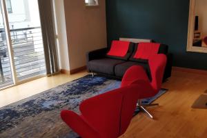 a living room with red chairs and a couch at West End & EICC with Parking in Edinburgh
