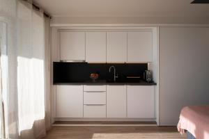 una cocina con armarios blancos y fregadero en #Lavaux, en Lutry