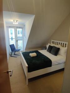 um quarto com uma cama branca e uma cadeira azul em West End & EICC with Parking em Edinburgo