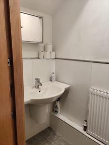 a white bathroom with a sink and a mirror at West End & EICC with Parking in Edinburgh